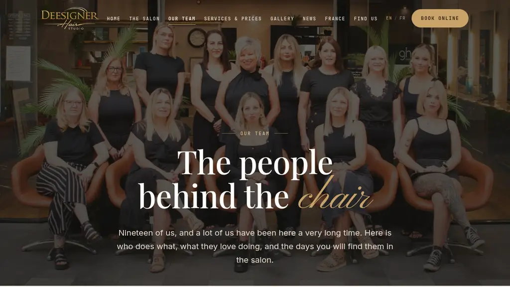 The Deesigner Hair team page, with all nineteen stylists photographed together on the salon floor